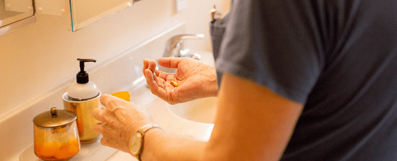 Person dispenses medications by hand at home.